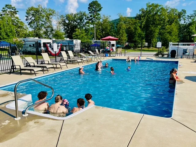 Campground guests swimming in a seasonal outdoor pool at Greensport