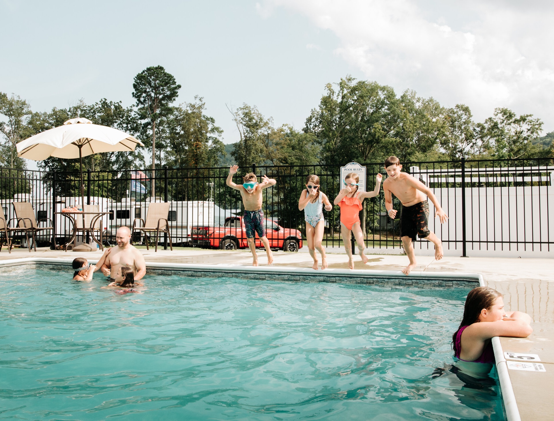 Kids jumping into the swimming pool
