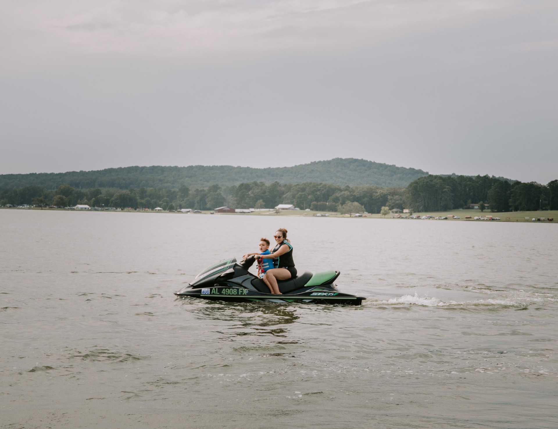 Adult and child riding a jet ski on the lake