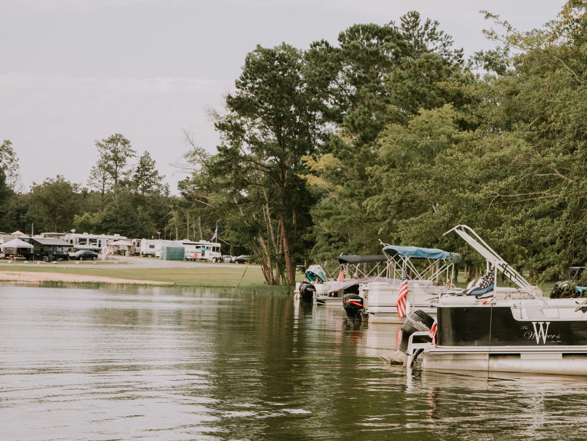 Pontoon boats docked along the lakeside campground