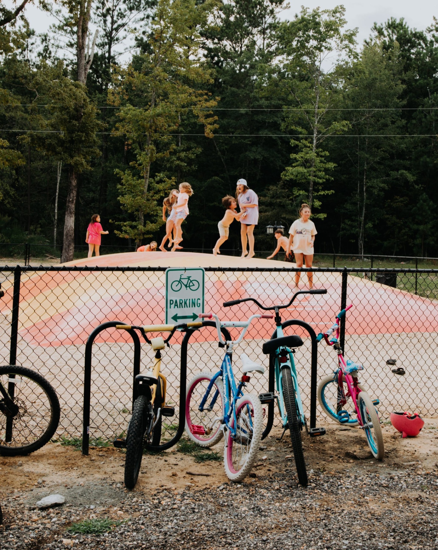 Kids playing on the jump pillow with bikes parked outside