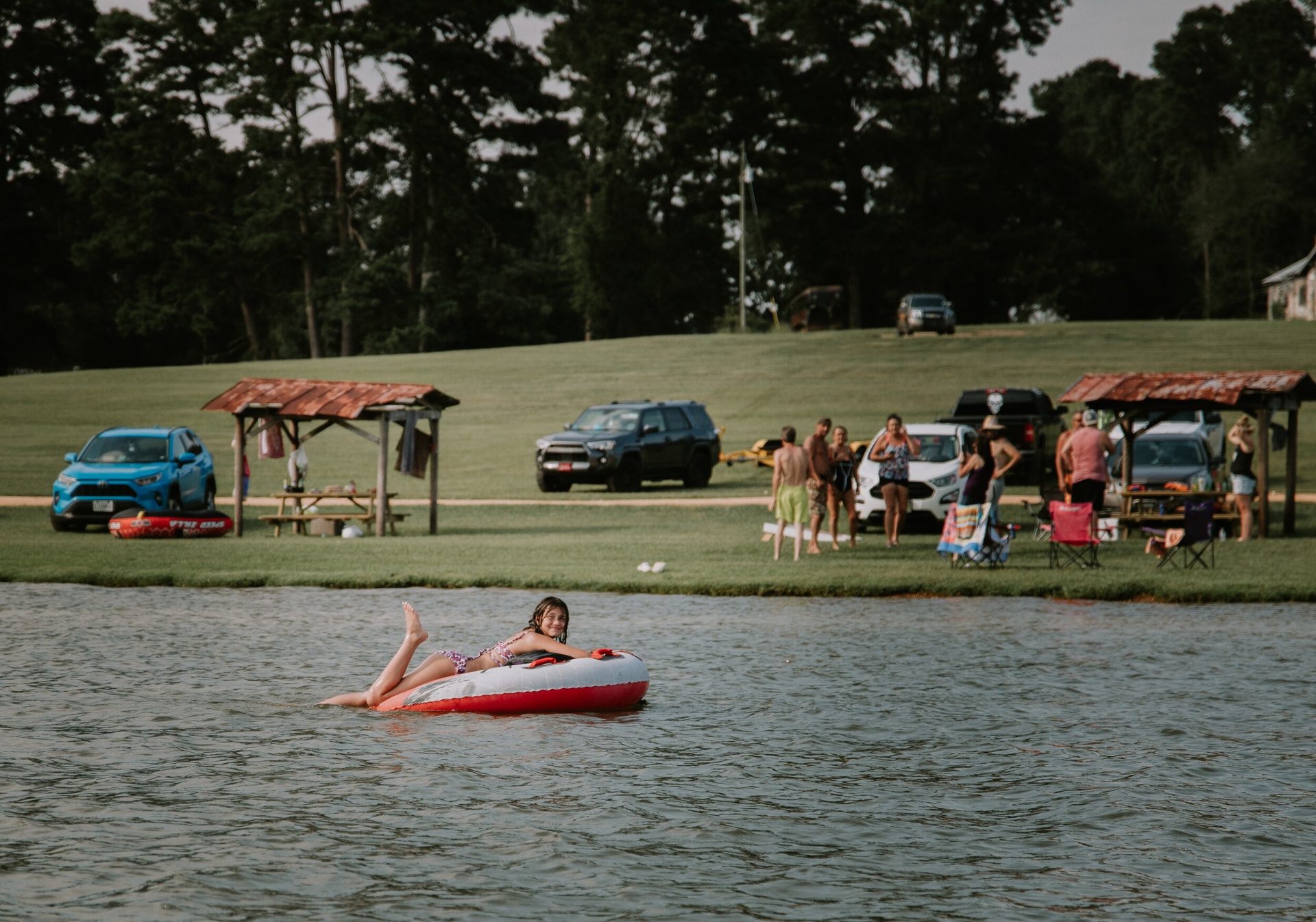 Child floating on an inner tube near the shoreline